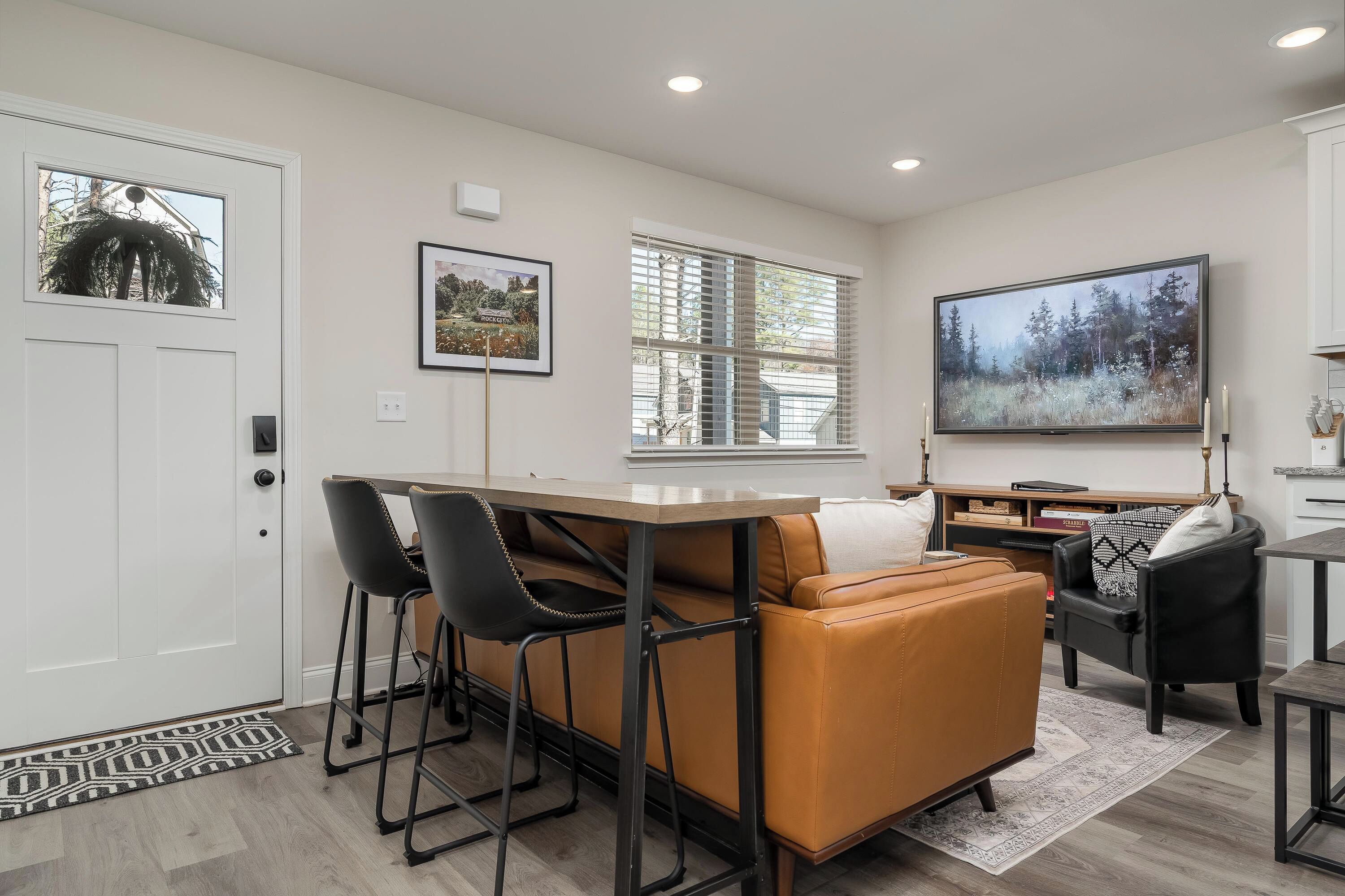 A modern living room with a sofa, chairs, a coffee table, and a TV.