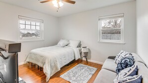 A bedroom with a bed, a ceiling fan, a nightstand, a dresser, a window, and a couch. - 5 Mi to Museum of the Great Plains: Home w/ Patio (Lawton)