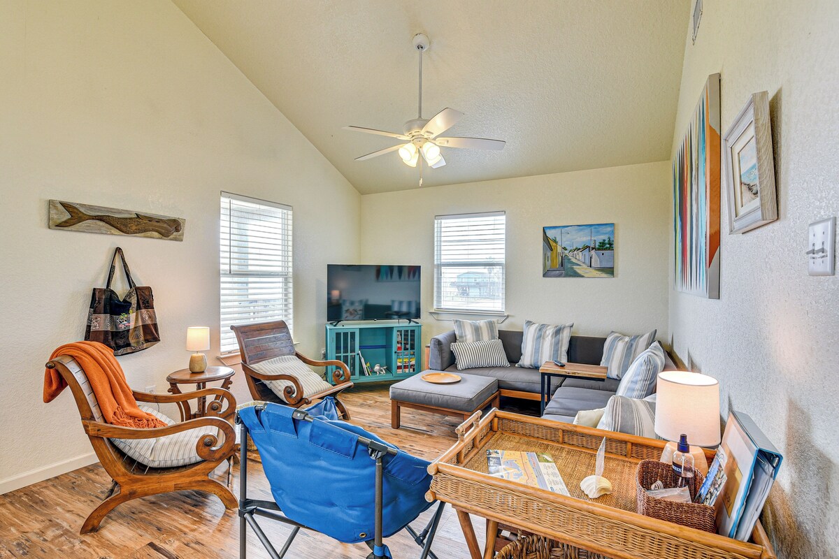 A living room with a sofa, chairs, a television, and a ceiling fan.