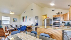 A modern kitchen with a central island, stainless steel appliances, and wooden cabinetry. - Walk to Beach; Surfside Beach Home w/ Deck (Freeport)