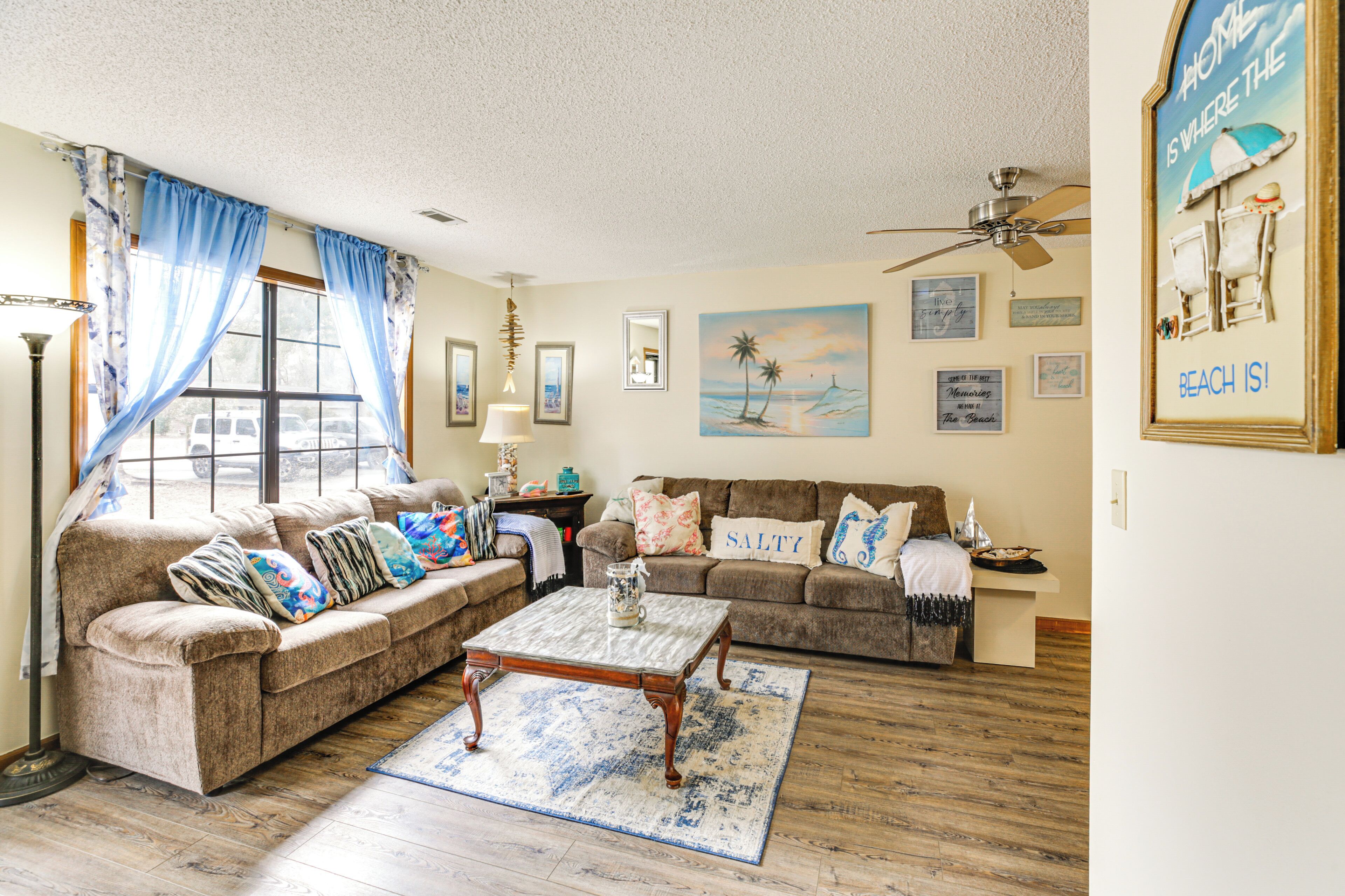 A living room with two sofas, a coffee table, and a ceiling fan.
