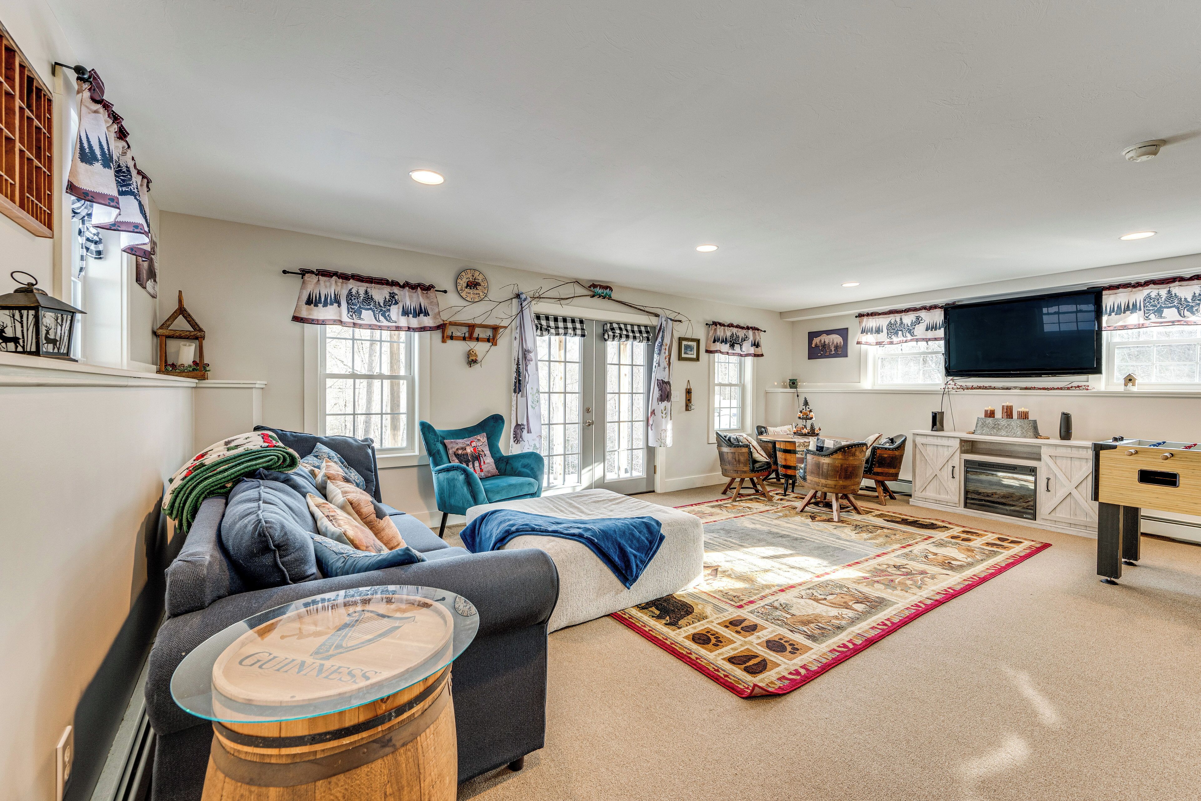 A cozy living room with a sofa, a coffee table, a fireplace, a television, and a dining area.