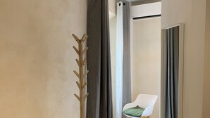 Une chambre à coucher avec un lit, une chaise et une fenêtre avec des rideaux.