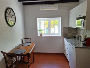 Apartamento superior, vista para o jardim | Cozinha privada | Frigobar, micro-ondas, torradeira, talheres/pratos/utensílios de cozinha
