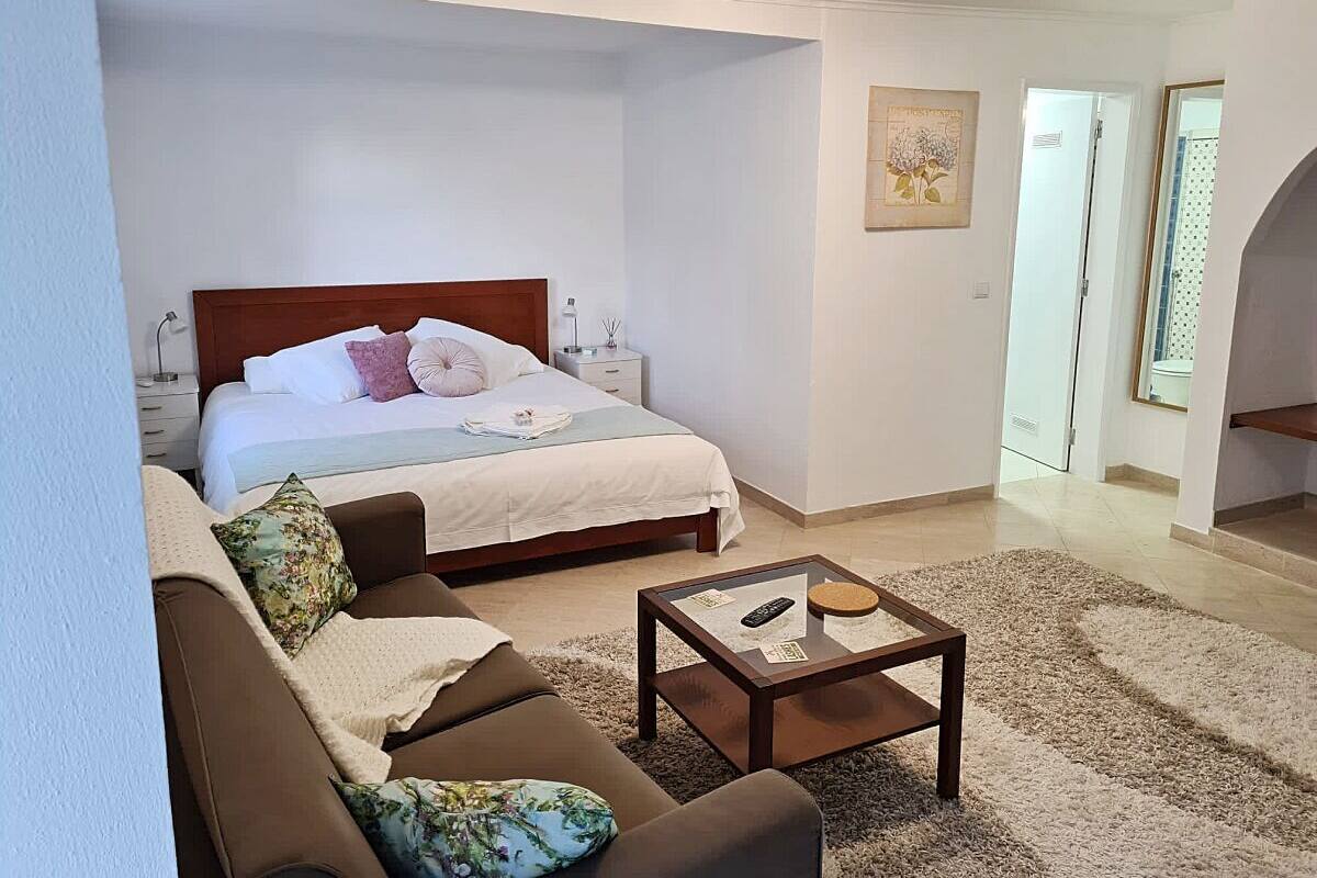 Une chambre à coucher comprenant un lit, une table de chevet, une table basse et un canapé.