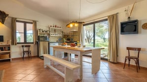 Une cuisine spacieuse dotée d’un grand îlot central, bénéficiant d’un éclairage naturel abondant et offrant une vue sur l’extérieur.