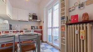 Una cocina con una mesa de comedor para dos personas, un radiador y varios electrodomésticos.