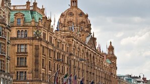 Een historisch gebouw met een opvallende koepel en verschillende vlaggen.