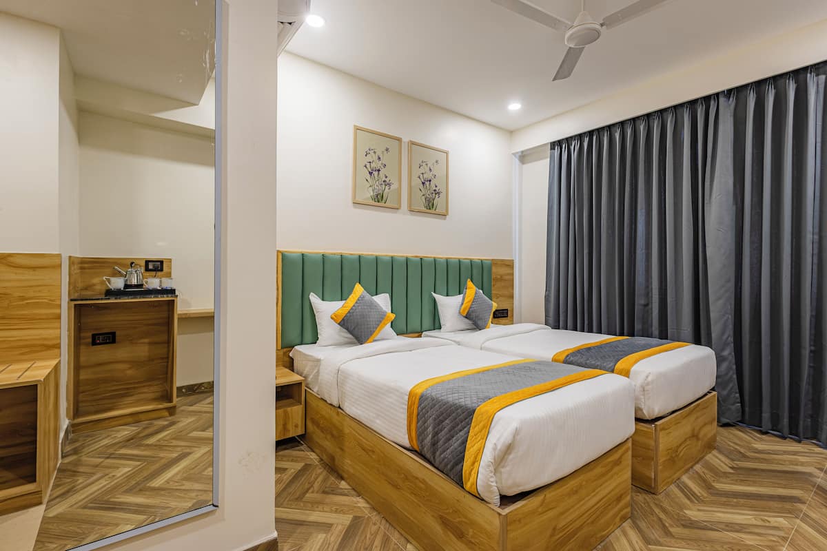 Una habitación de hotel con una cama grande, cabecera de madera, dos mesitas de noche y un espejo.