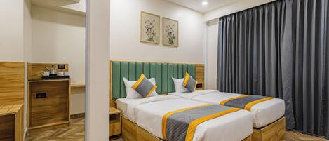 Une chambre d’hôtel avec un grand lit, une tête de lit en bois, deux tables de chevet, une commode et un miroir.
