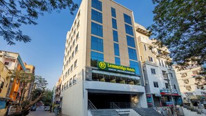 Un edificio de varios pisos con un letrero destacado de Lemonridge Hotels, que cuenta con un salón de banquetes, restaurante y habitaciones.