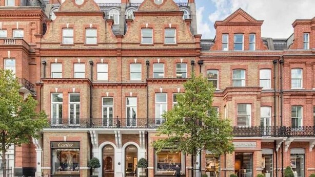 A row of red brick townhouses with a storefront labeled "Cartier" on the ground floor. - Spacious Luxury Flat with Garden in Central London (London)