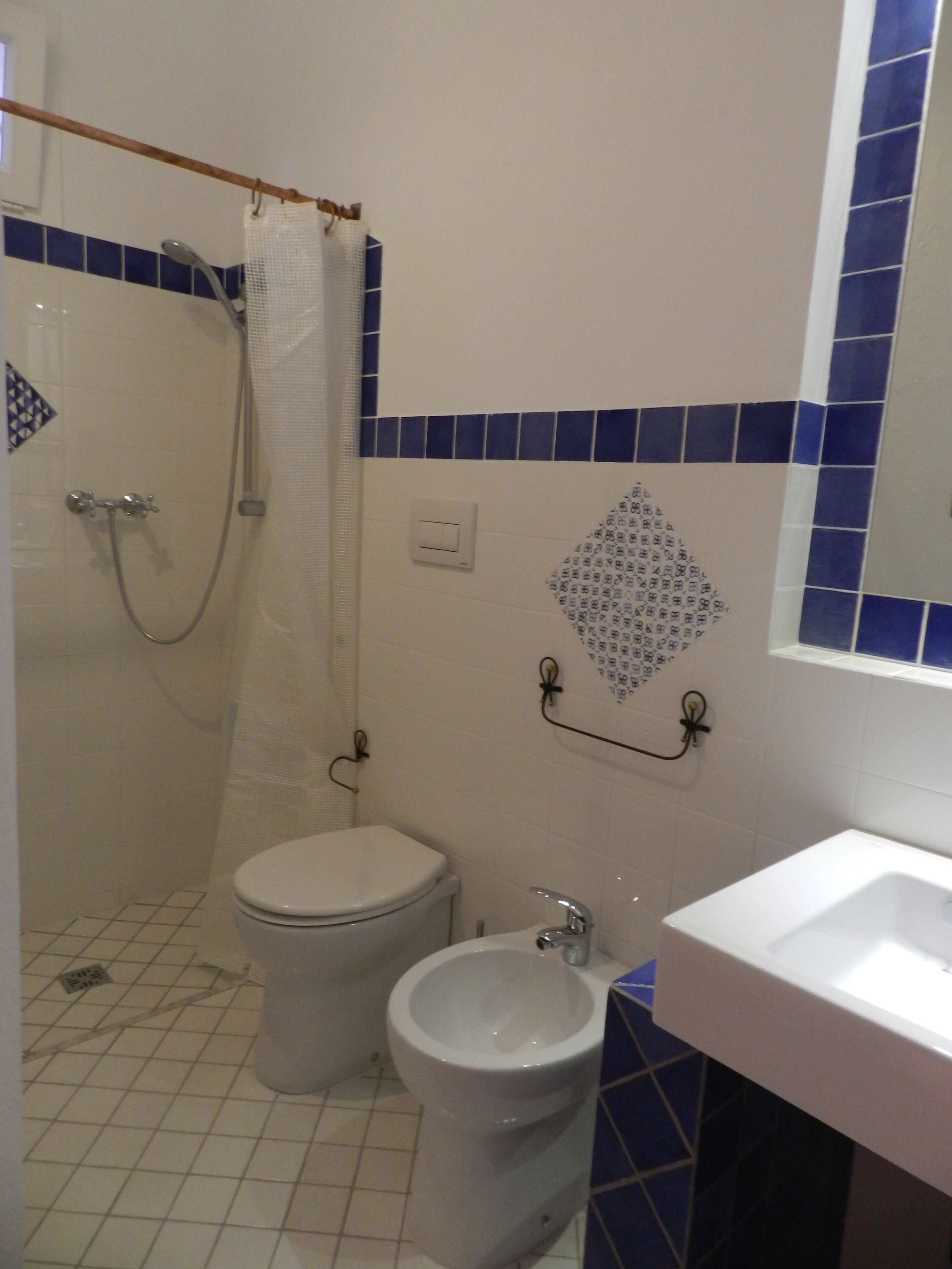 Un baño con inodoro, bidé y lavamanos.