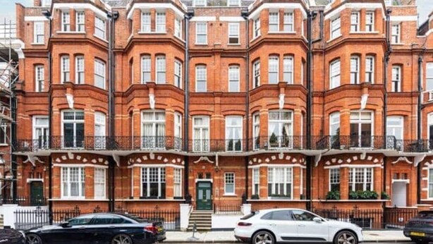 A row of red brick terraced houses with white window frames and black railings. - Luxury Flat in a Great Location / Harrods (London)