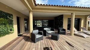 A covered outdoor patio with wooden flooring, outdoor furniture, and a view of the surrounding landscape. - RECENT CORSICAN VILLA 150m2 SWIMMING POOL BEACHES LEISURE AREA (Lecci)