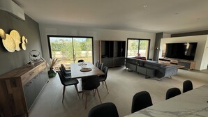 A modern kitchen with a dining area, large windows, and a TV. - RECENT CORSICAN VILLA 150m2 SWIMMING POOL BEACHES LEISURE AREA (Lecci)