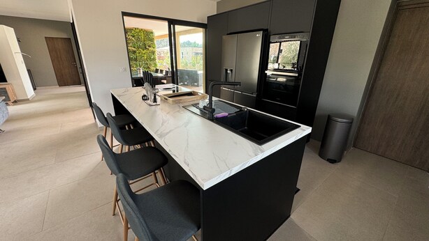 A modern kitchen with a large island, black cabinetry, and stainless steel appliances. - RECENT CORSICAN VILLA 150m2 SWIMMING POOL BEACHES LEISURE AREA (Lecci)