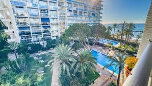 Hotel com vários andares e varandas com vista para uma área de piscina e o mar.