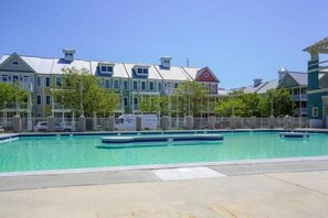 A swimming pool with a clear blue water, surrounded by a fence, and buildings in the background. - Sunset Island - 39 Fountain Drive West 3f 3 Bedroom Condo (Ocean City)