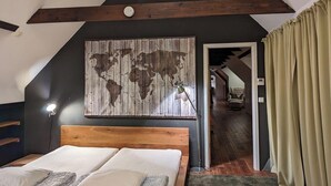 Un dormitori amb un panell de capçal de fusta, una obra d'art amb un mapa mundial i vista a un passadís.
