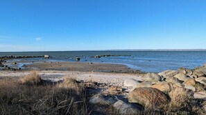 A rocky beach with calm water and clear skies.