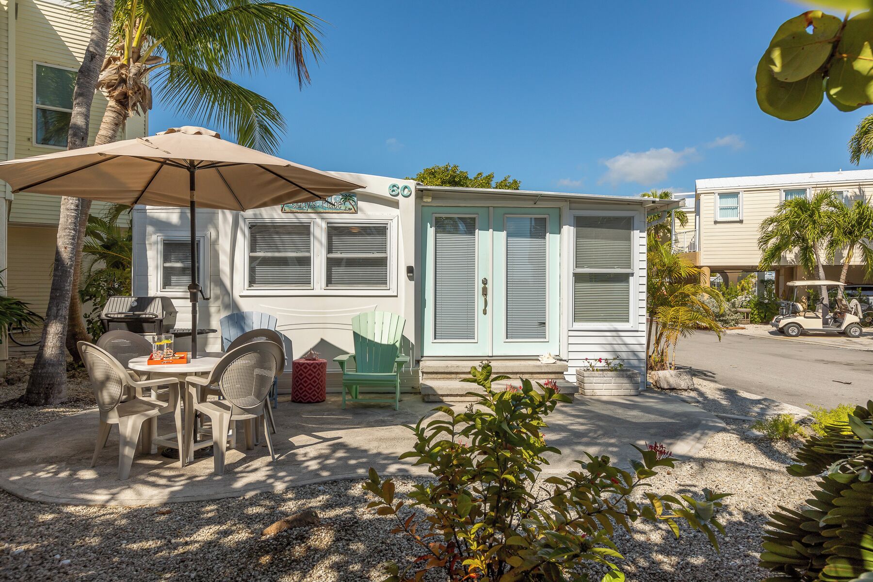 A mobile home with a patio area, outdoor seating, and a barbecue grill.