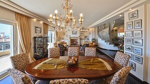 A spacious dining area with a chandelier, patterned chairs, and a wooden table. - VILLA DOMUS RIVIERA with exclusive pool and breathtaking panoramic views (Voula)