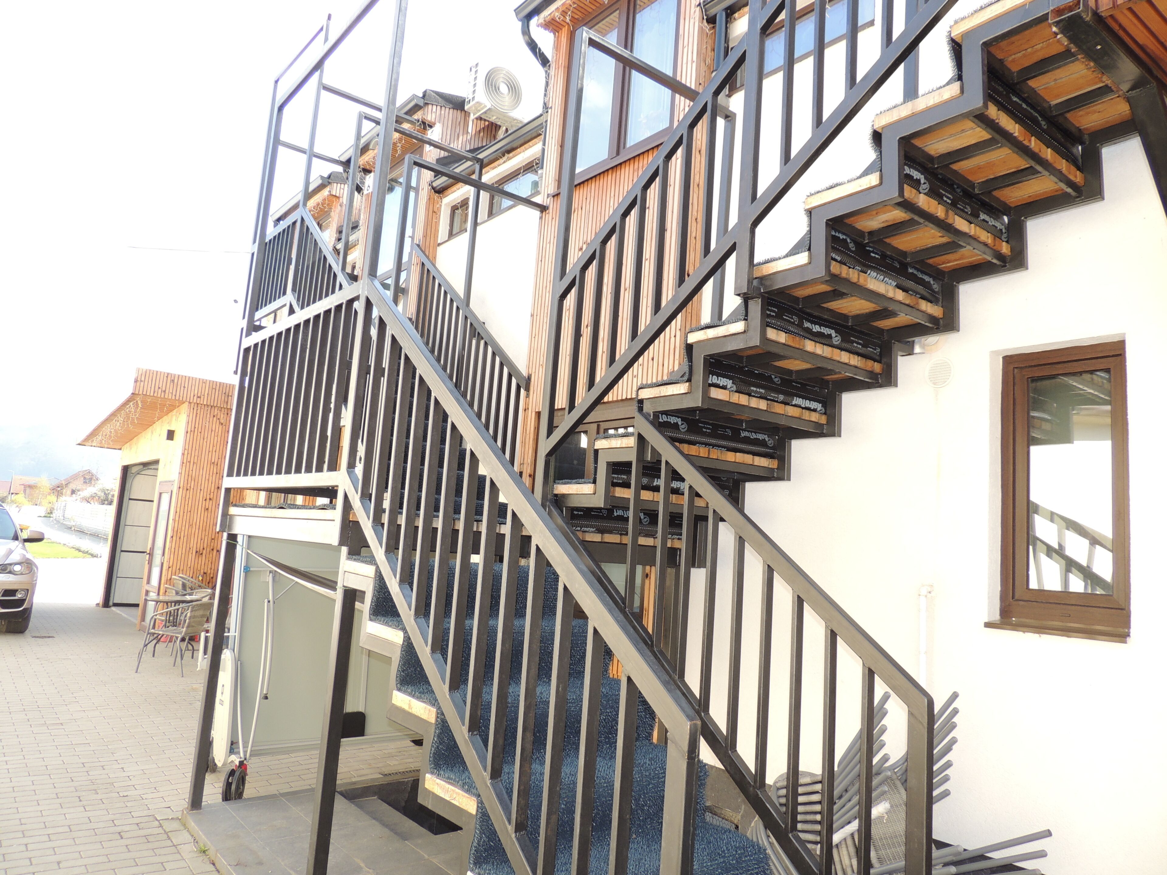 Ein mehrstöckiges Gebäude mit einer Treppe und einer Tür zu einem überdachten Außenbereich.
