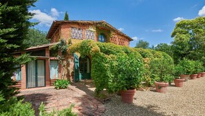 A rustic brick house with ivy-covered walls, a gravel driveway, and potted plants. - Giunchette Meri, Cavriglia, Arezzo and Cortona (Cavriglia)