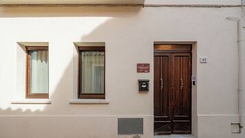Une façade d’immeuble avec deux fenêtres, une porte en bois et une enseigne indiquant le nom « Sorella Luna ».