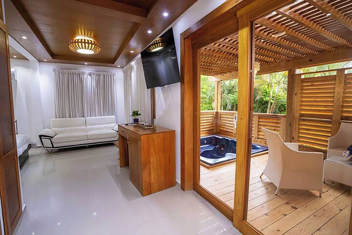 Una sala de estar moderna con un sofá blanco, una mesa de centro de madera y un televisor montado en la pared.