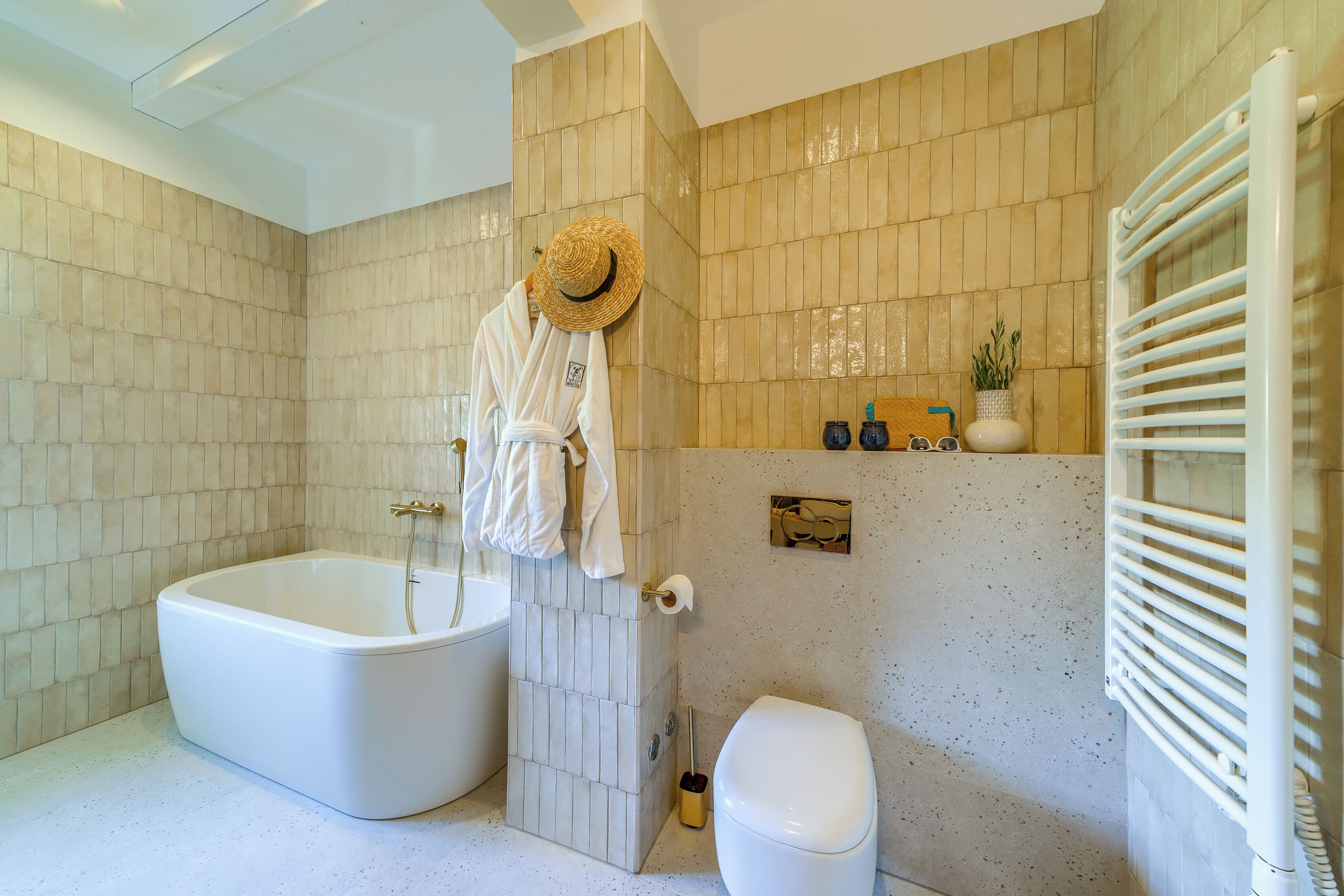 A bathroom with a bathtub, toilet, and towel rack.