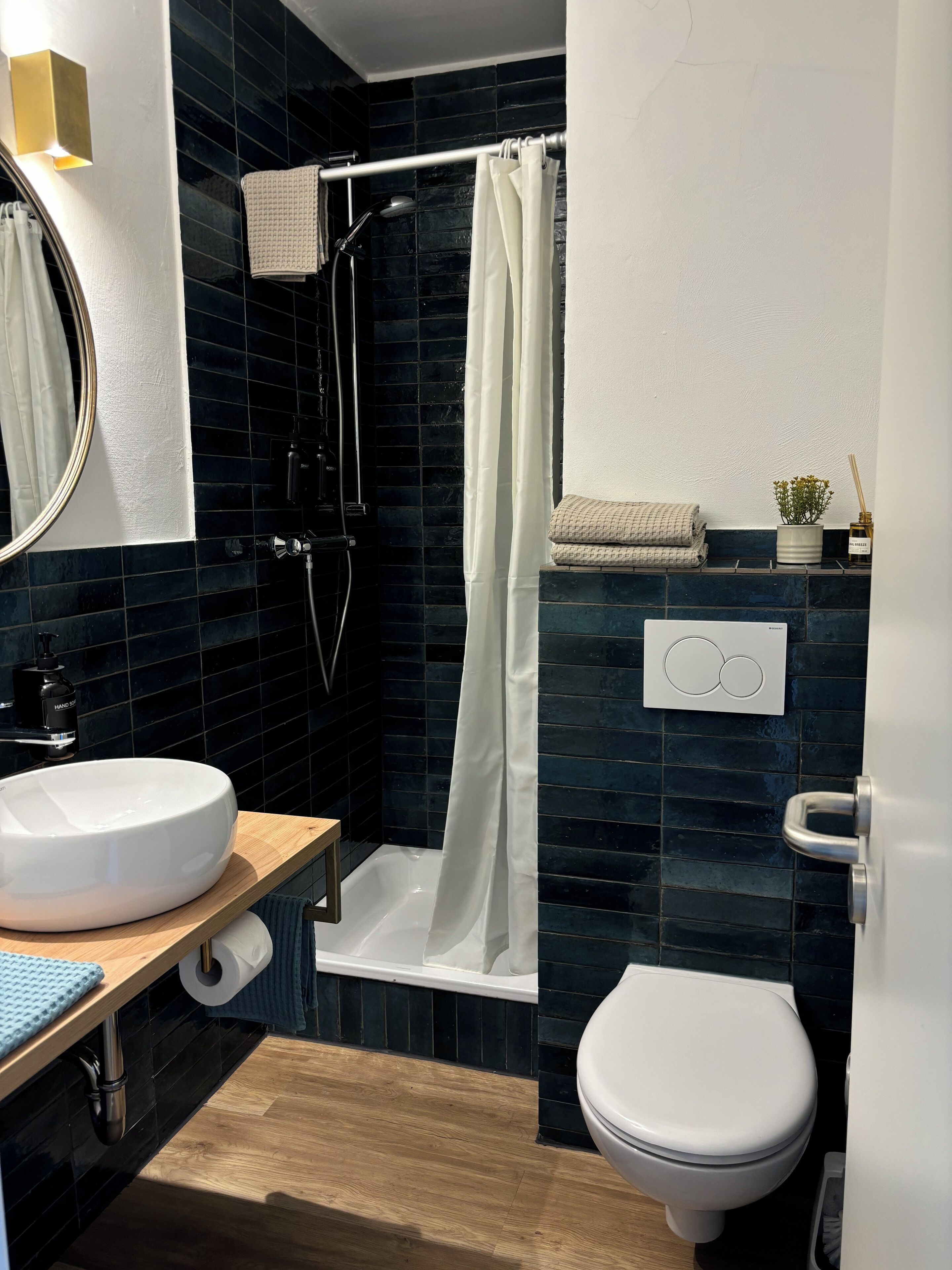 Une salle de bain moderne avec un lavabo blanc, des toilettes et un espace douche.