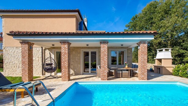 A poolside area with a covered patio, a hanging chair, and a barbecue grill. - Family Villa Di with pool (Malinska)