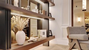 A modern living room with a wooden console table, a large mirror, and a comfortable armchair. - LUXE- A PERFECT BLEND OF CHARM, COMFORT & MODERNITY SAINT GERMAIN- RUE DE RENNES (Paris)