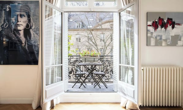 Una stanza con vista su un balcone, un termosifone e un'opera d'arte incorniciata.