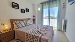 A bedroom with a bed, bedside table, lamp, and a view of the outdoors. - Bedroom Apartment in La Vileta-Palma · Balcony & Easy Parking (Sa Vileta-Son Rapinya)