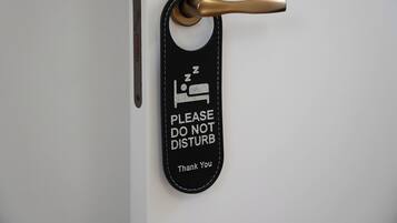 Una puerta con un letrero negro que dice 'PLEASE DO NOT DISTURB Thank You'.