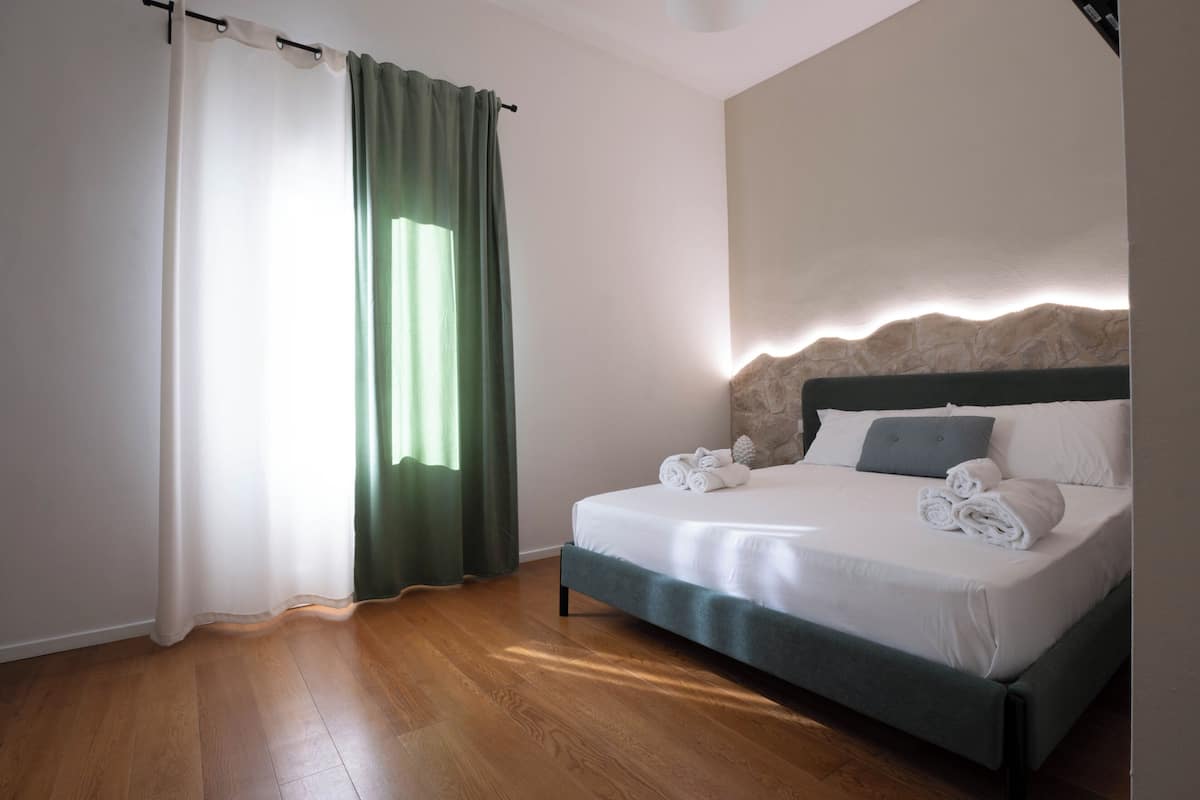A hotel room with a bed, curtains, and a headboard.