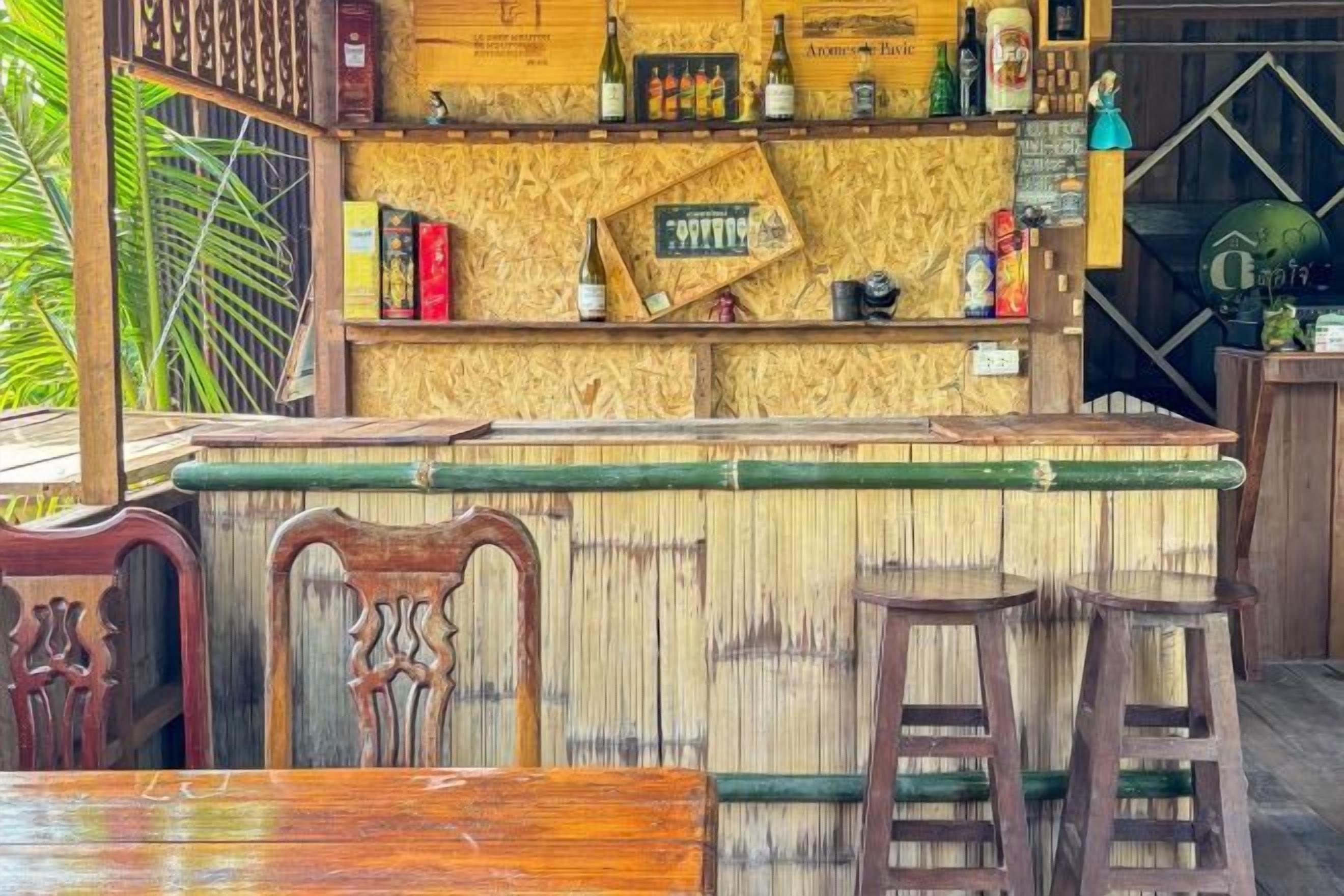 A bar area with wooden furniture, a counter with various bottles, and a rustic decor.