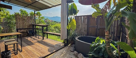 A wooden deck with a hot tub and outdoor seating.