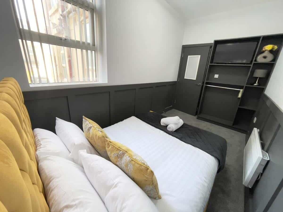 Une chambre d’hôtel avec un lit, une fenêtre, une armoire et un radiateur.