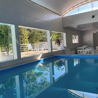 Una piscina cubierta, una piscina al aire libre, sombrillas, tumbonas