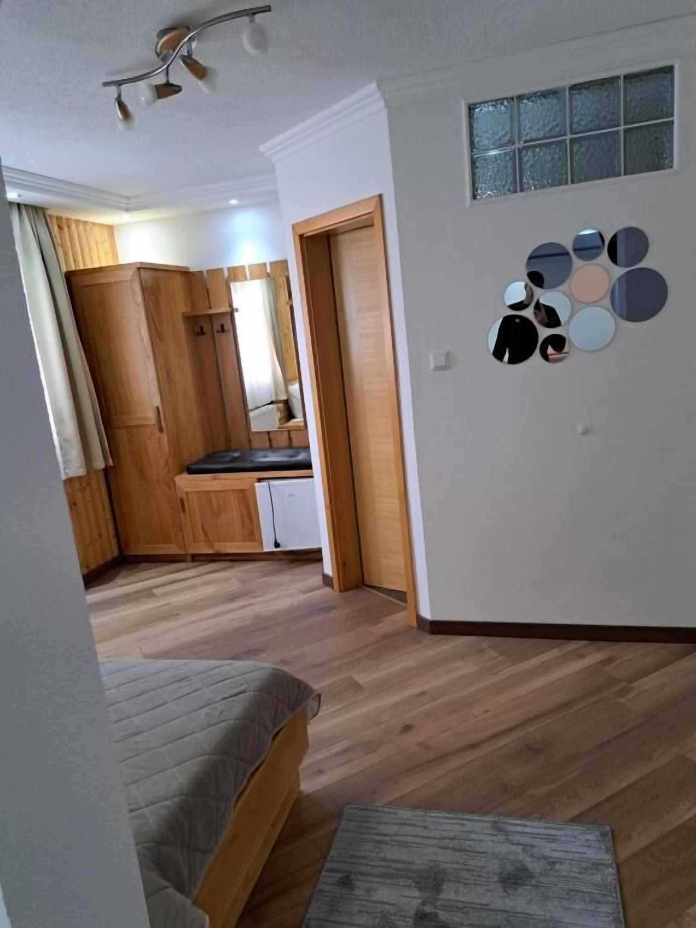 A compact room with a bed, a small table, and a kitchenette.