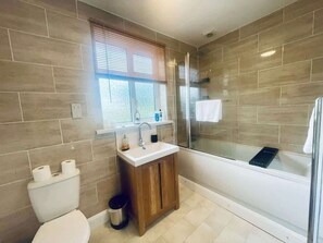 A bathroom with a toilet, sink, and bathtub.
