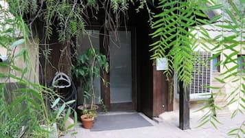 Welcome to a serene entrance with lush greenery and a beautifully maintained outdoor space.