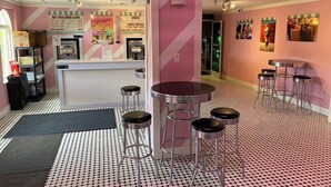 A retro-themed café with a pink and white striped wall, a counter with a menu, and bar stools. - Spacious 4 BD townhome: w/Pool, hot tubs, Lazy River, A/C & Wi-Fi, Near Disney! (Davenport)