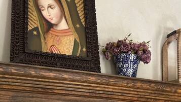 A framed religious icon with a floral vase beside it.
