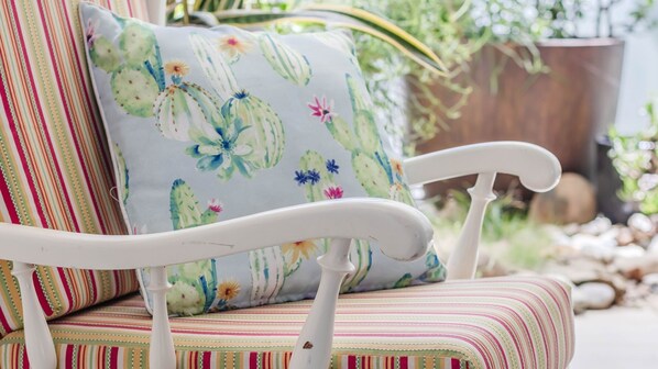 A white metal chair with a striped cushion.