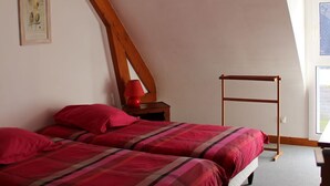 A bedroom with a sloped ceiling, a bed with red bedding, a red lamp on a nightstand, and a wooden ladder against the wall. - House CARNAC - 300 meters from Légenèse beach (Carnac)